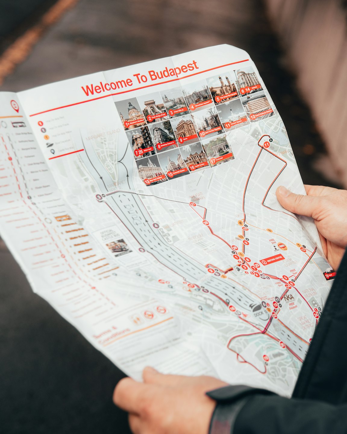 Hands hold a tourist map of Budapest with a marked route.
